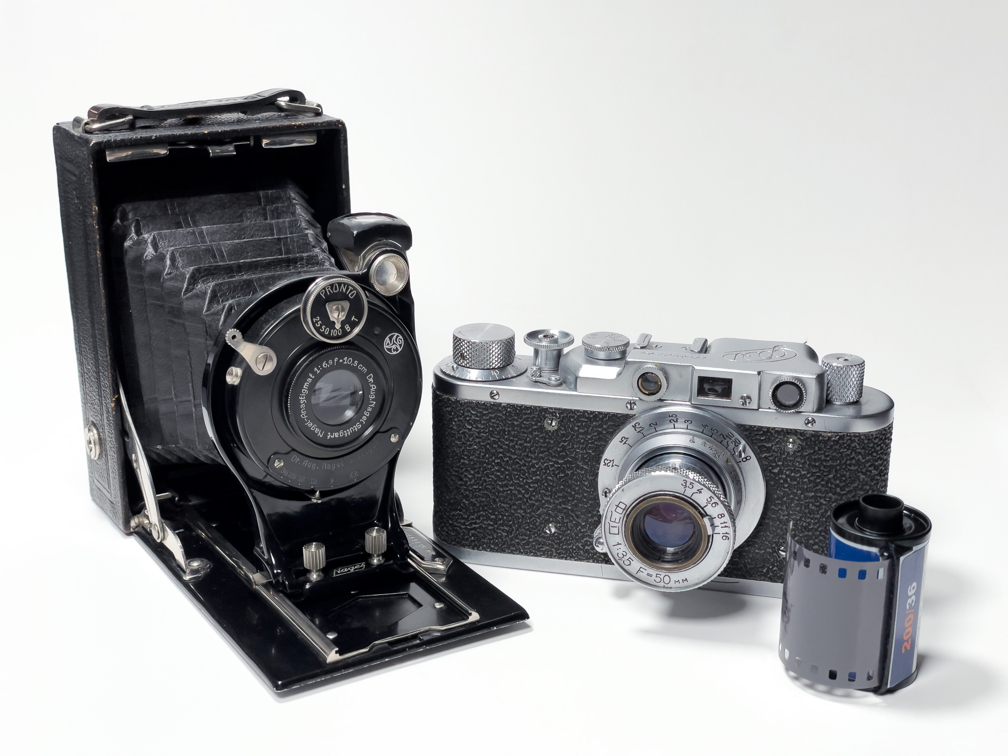 Zwei analoge Kameras und eine Filmpatrone werden in diesem Schwarz/Weiss-Bild gezeigt