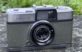 Die Filmkamera Olympus Pen (Model 3) von schräg oben präsentiert.