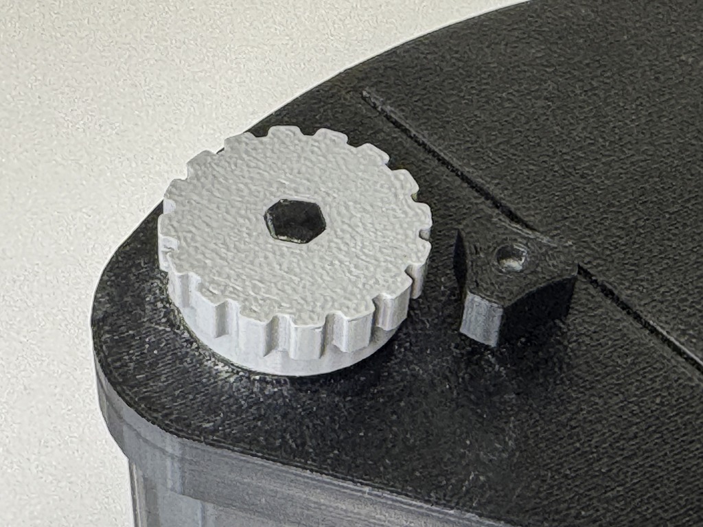 Detailaufnahme mit Transportknopf und Verschlussschraube.