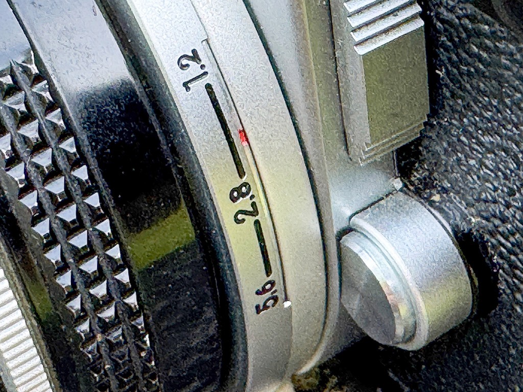 Nach dem Prozess der mechanischen Kupplung ist auf dem Verschlusszeitenring in derentsprechenden Skala die maximale Blendenöffnung des Objketivs markiert