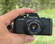 Die PENTAX auto 110 zwischen Daumen und Zeigefinter in der Hand gehalten.